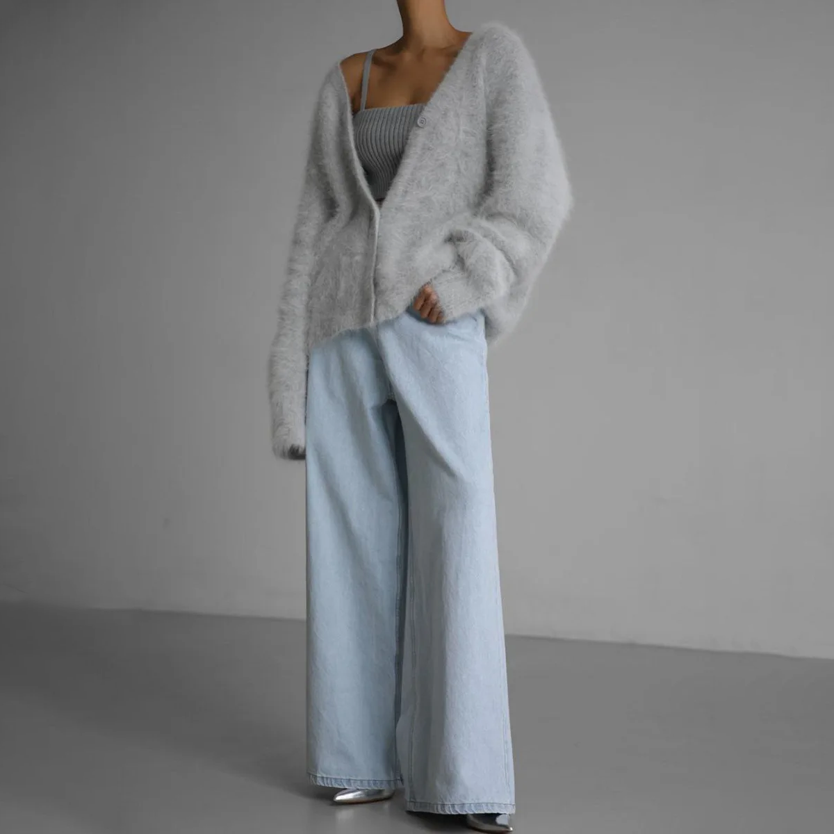 Light grey cardigan worn open with pale blue trousers.
