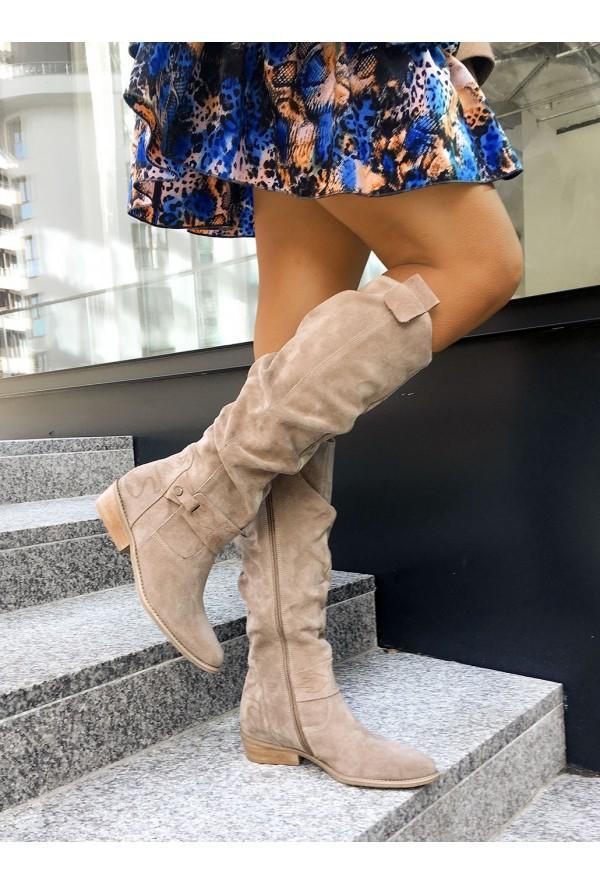 Beige boots with gathered shafts worn on stone steps.