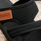 Close view of black mesh straps, stitched edges and a patch reading Fashion.