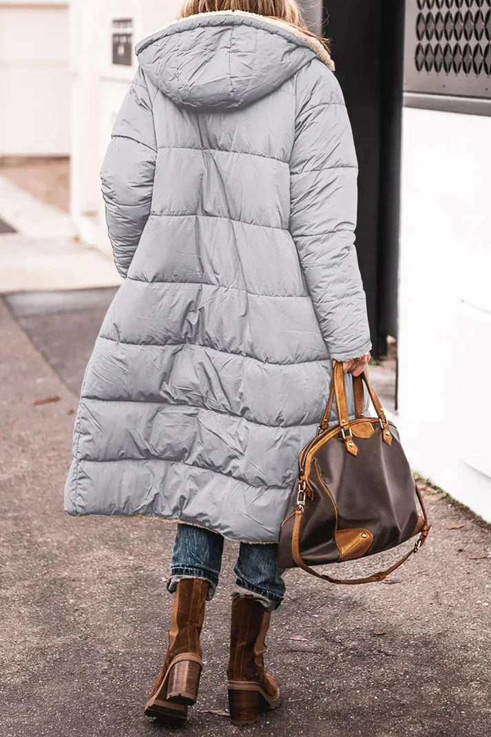 Rear view of the grey coat showing quilting and a hood.