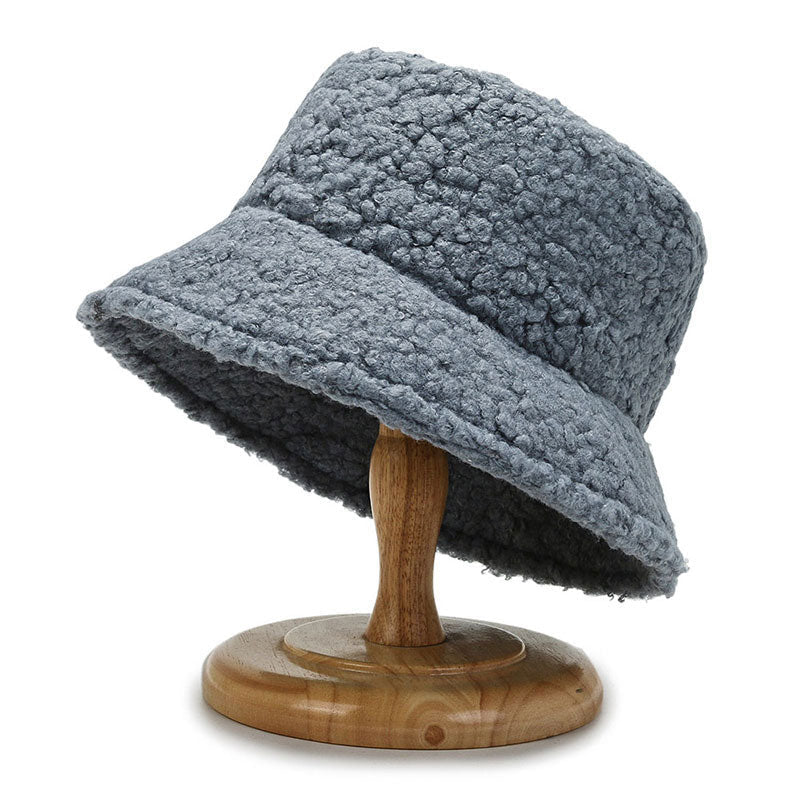Grey bucket hat with a textured surface and downturned brim.