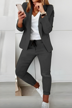 Dark Grey open-front blazer and drawstring trousers shown with a contrasting top and white trainers.