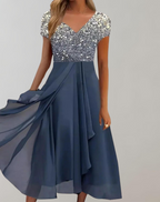 Silver sparkling short-sleeved top above a blue skirt.