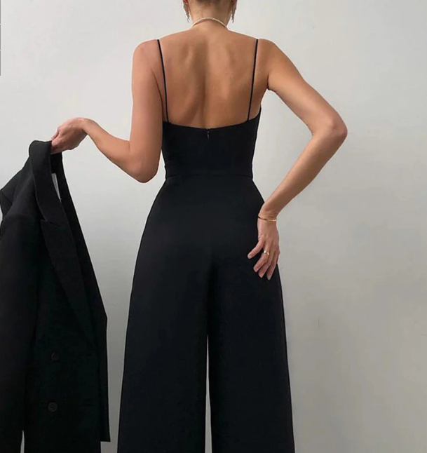 Back view of the black jumpsuit showing slim straps and a low straight back.