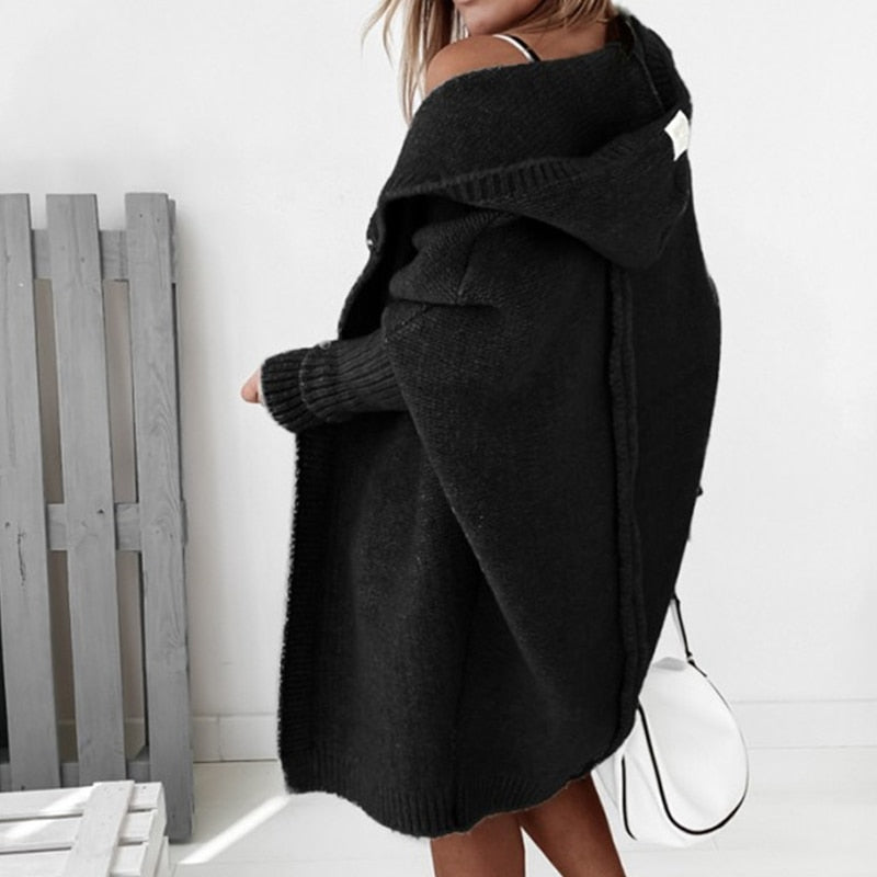 Rear view of the black cardigan showing its hood and long hem.