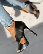 Black peep-toe shoe shown from the side, with a slim high heel and curved cutout.