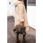 Side view of the coat worn with its cream teddy side out.