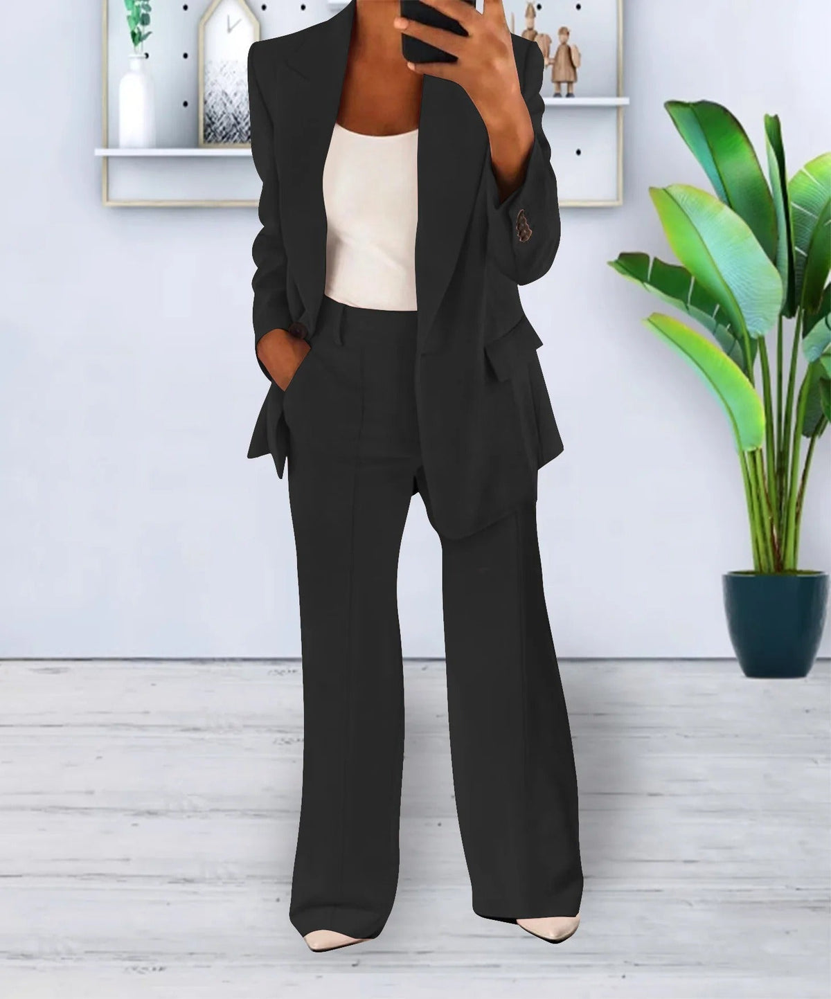 Black lapel jacket and matching trousers, worn with a white top.