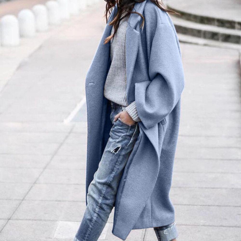 Blue oversized coat worn with a grey jumper and jeans.