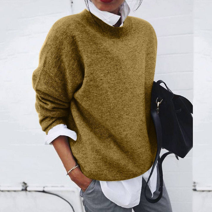 Ochre-coloured round-neck jumper layered over a white collared shirt.