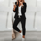 Black blazer and tapered drawstring trousers, worn with white trainers.
