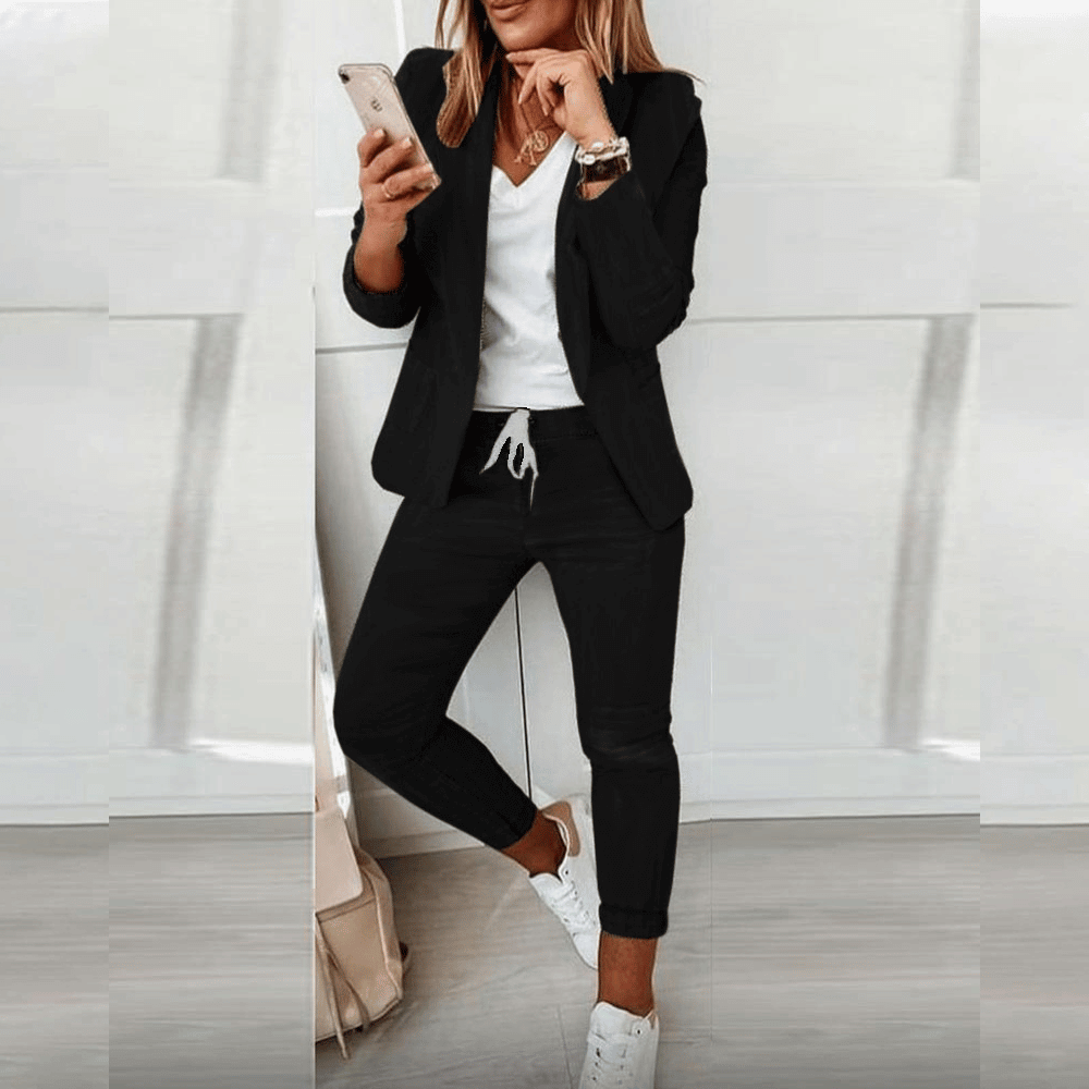 Black blazer and tapered drawstring trousers, worn with white trainers.