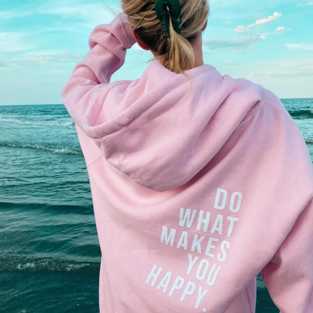 Back of a pastel pink oversized hoodie with the slogan Do What Makes You Happy.