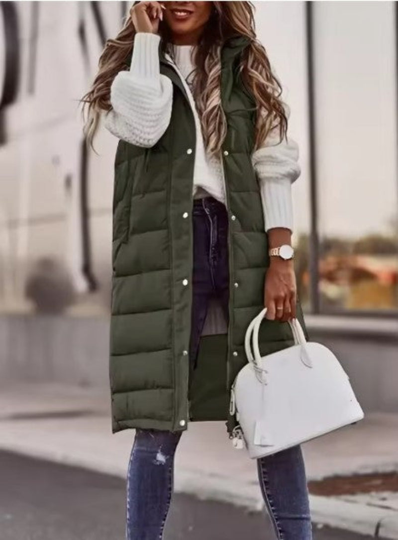 Army green long quilted gilet worn open with jeans.