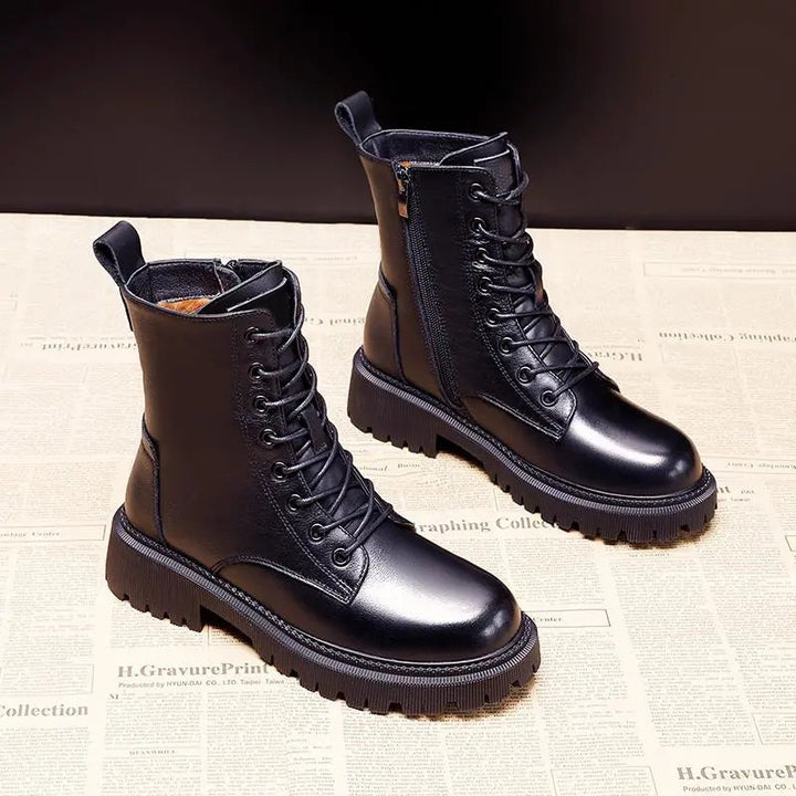 Pair of black lace-up boots with side zips, rounded toes and chunky soles.
