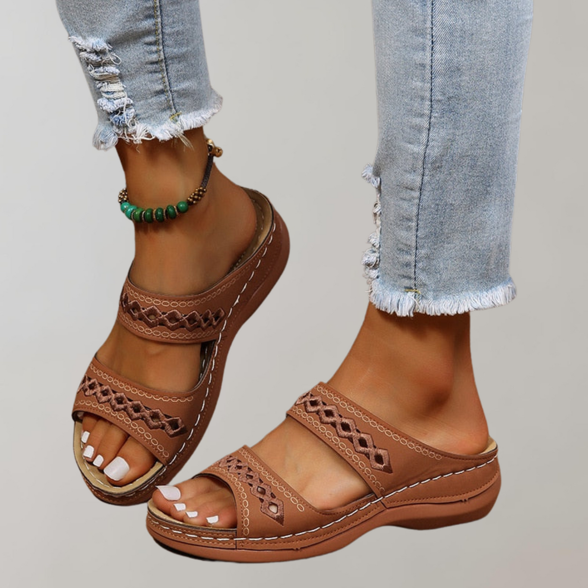 Dark-brown slide sandals with contrasting stitched borders.