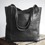 Black leather tote with long handles and a large front pocket.