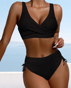 Front view of black bikini shown against a blue sky.
