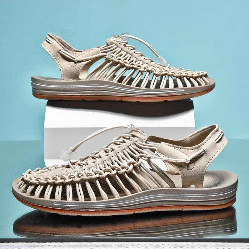 Beige cord sandals with brown-edged soles shown on display blocks.