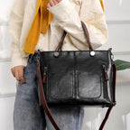 Black handbag carried by its brown handles.