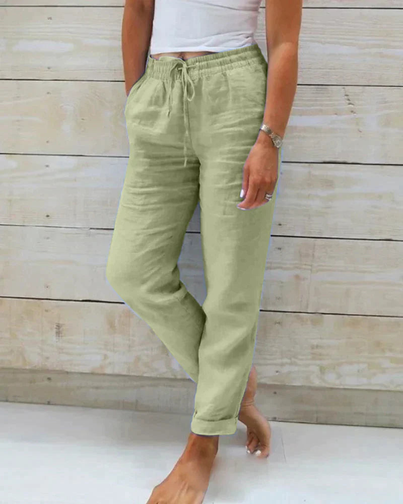 Green drawstring trousers with a relaxed leg and rolled hems.