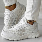 Side view of white floral trainers showing reinforced panels and deep sole grooves.