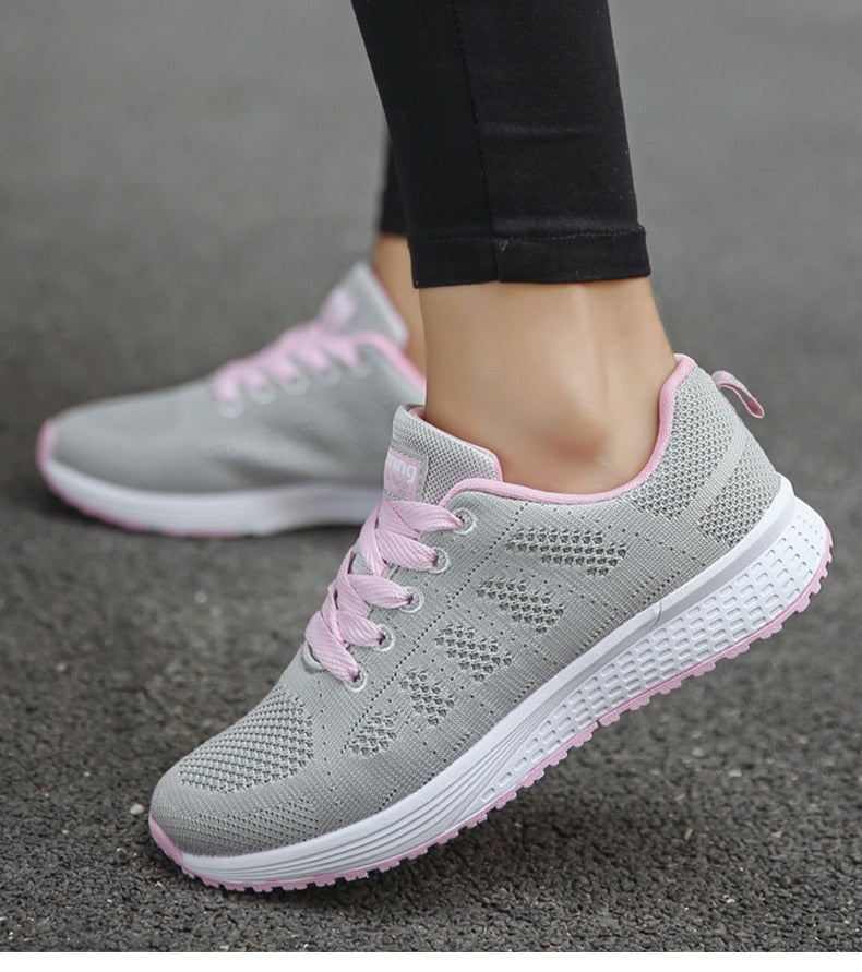 Grey trainers with pale pink laces shown from the side.