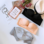 Black and beige strapless bras beside the back of a grey bra.