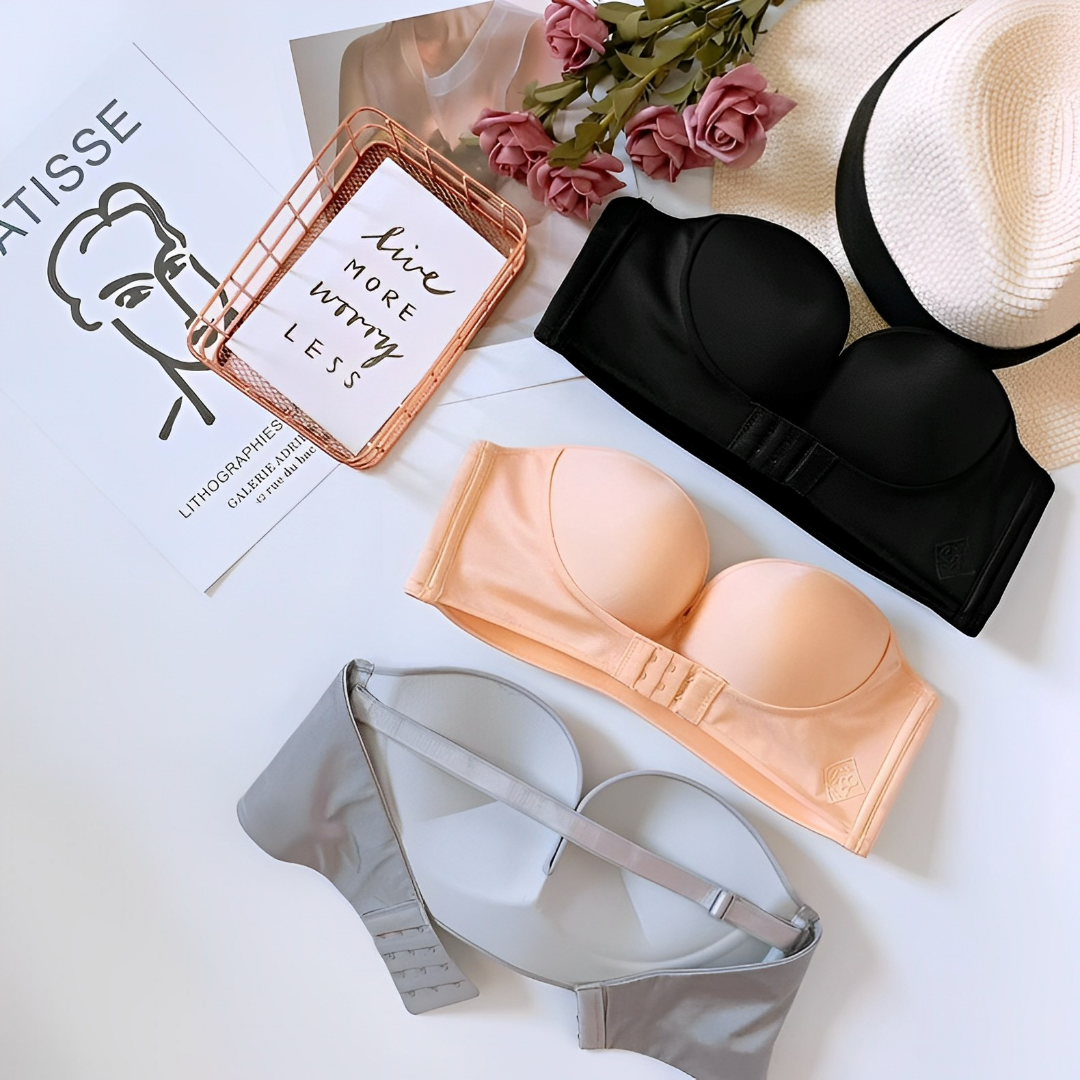 Black and beige strapless bras beside the back of a grey bra.