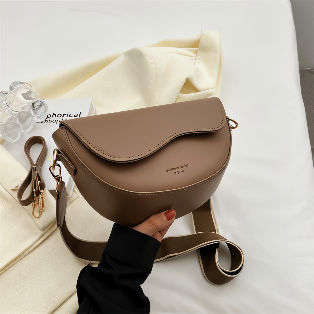 Taupe shoulder bag with a curved flap and metal strap fittings.