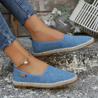 Sky blue canvas espadrilles with flat soles and woven-look trim.