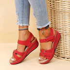 Red sandals shown from the side with the heel straps visible.