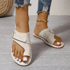 White toe-loop sandals with adjustable straps and metallic side buckles.