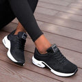 Black lace-up trainers with white soles and tongue labels.
