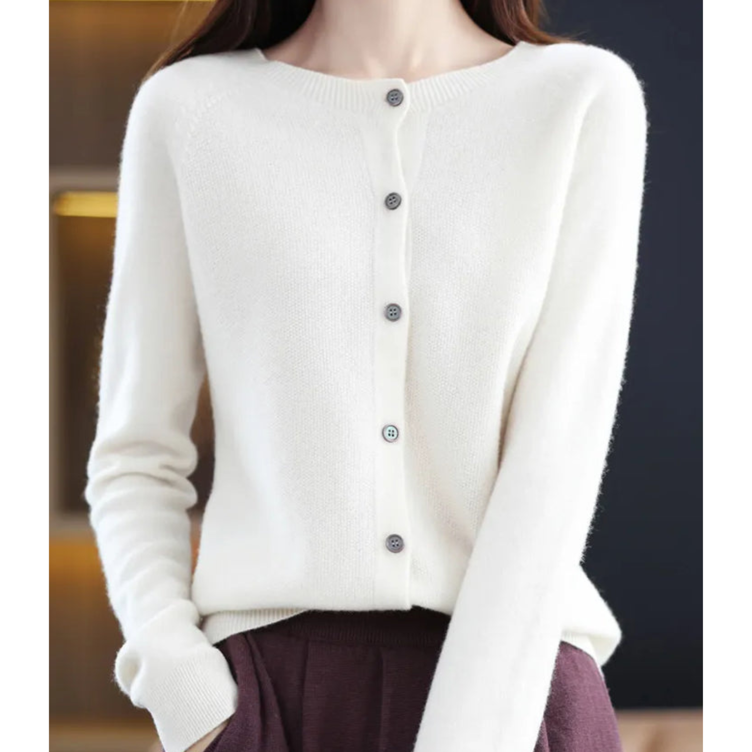 White cardigan with a button front and long sleeves.