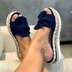 Dark blue bow sandals with raised platform soles.