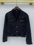 Black denim jacket shown from the front on a wooden hanger.