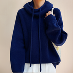 Blue jumper with a drawstring cowl neck and wide sleeves.