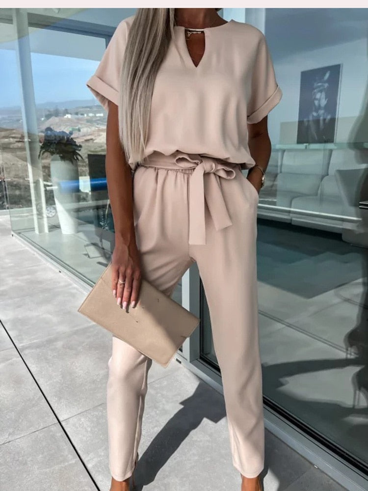 Khaki jumpsuit with turned sleeve edges and a waist tie.