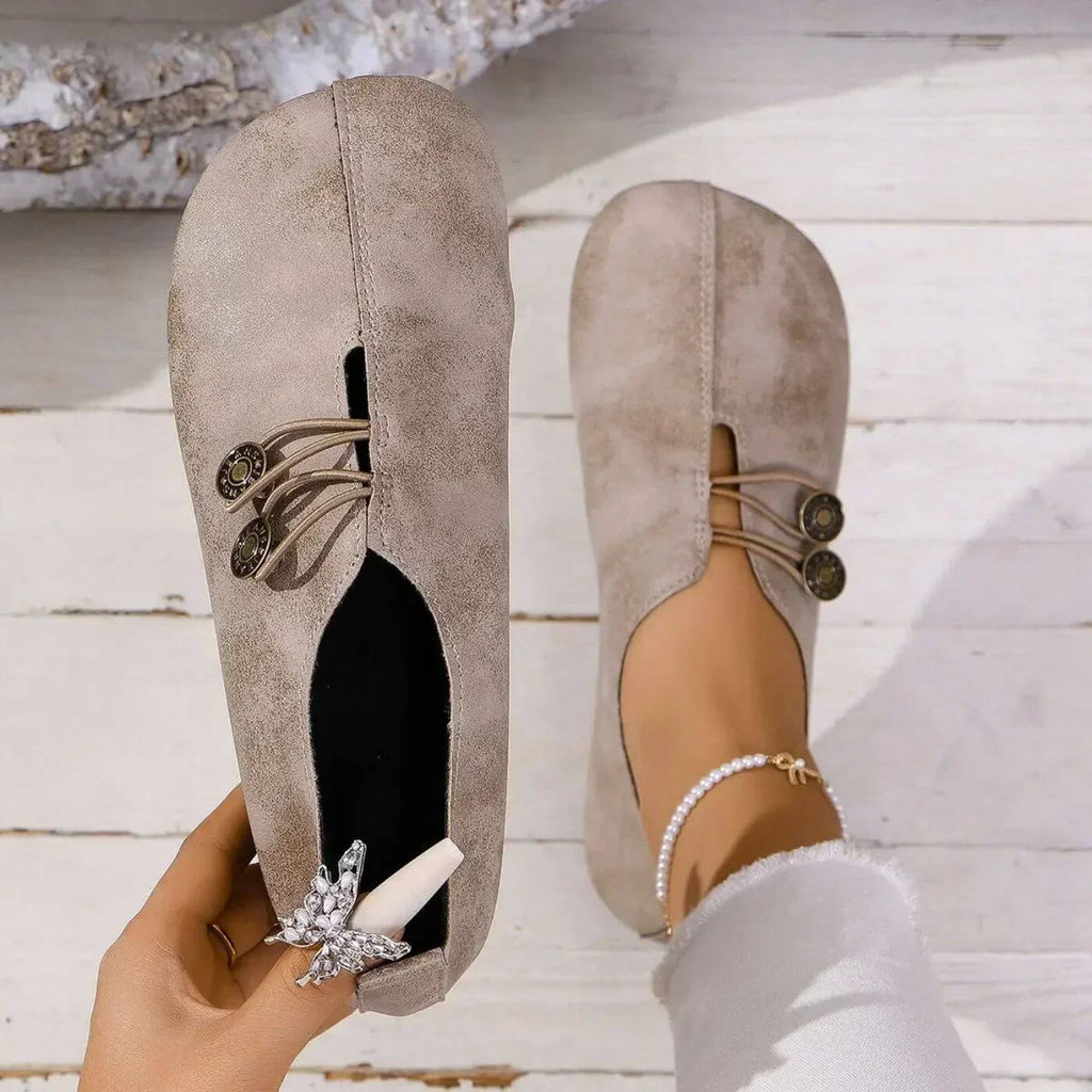 Top view of light brown slip-on shoes with decorative lacing.