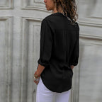 Black blouse worn from the back with rolled sleeves.