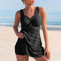 Black skirted swimsuit with a gathered bodice, front tie and patterned skirt panel.