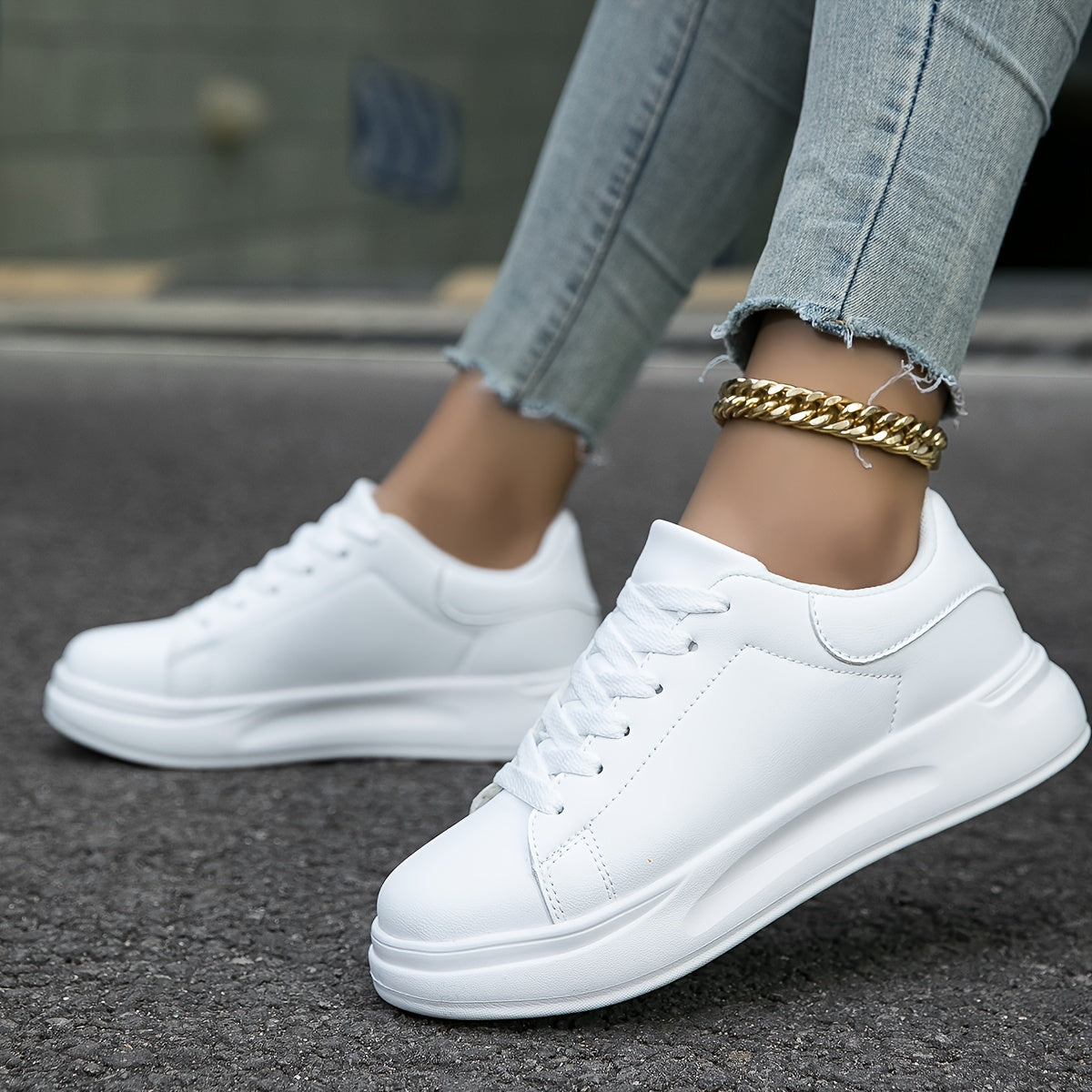 White lace-up trainers with smooth panels, rounded toes and thick white soles.