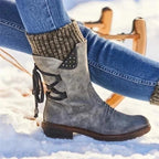 Grey knit-cuff boots worn with jeans on snow.