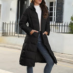 Black quilted coat worn open with hands resting in the outside pockets.
