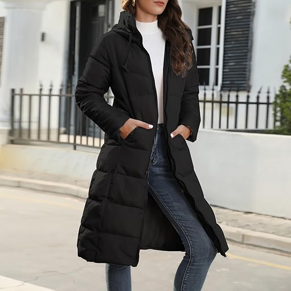 Black quilted coat worn open with hands resting in the outside pockets.