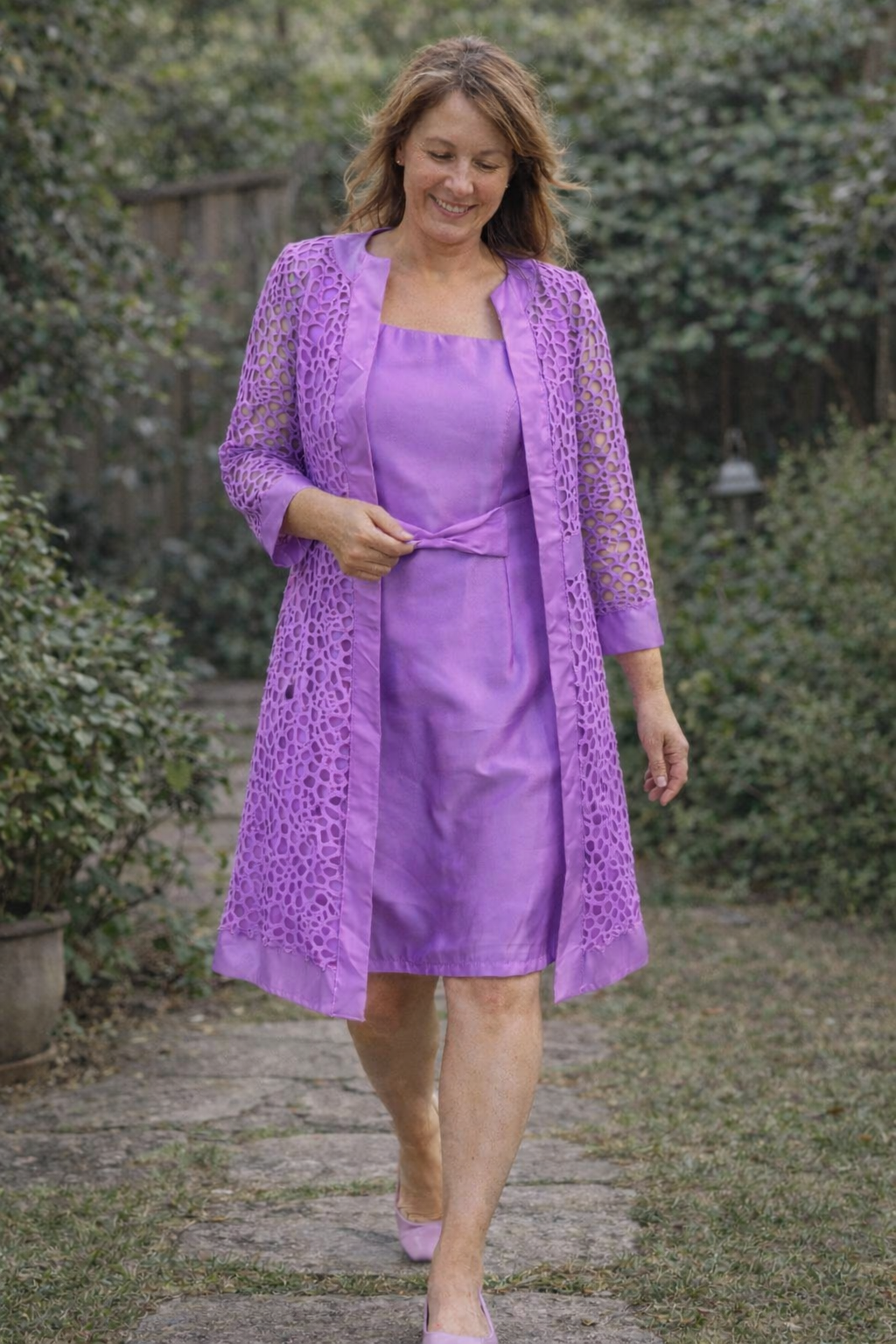 Purple dress and open jacket with patterned sleeves.