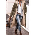 Army green quilted jacket shown open with one hand in a pocket.