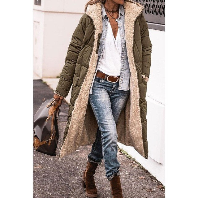 Army green quilted jacket shown open with one hand in a pocket.