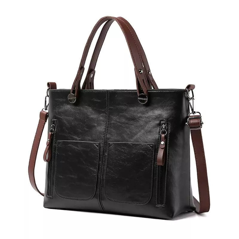 Black handbag with front pockets and a detachable brown strap.